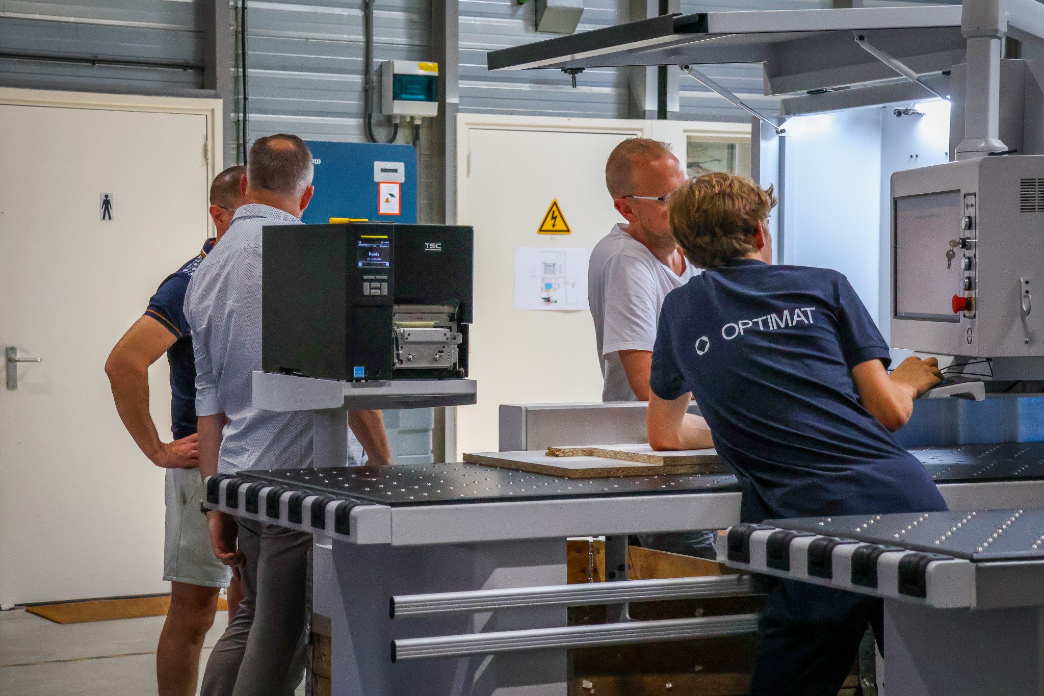 Een OPTIMAT-specialist geeft bezoekers uitleg aan een KDT-machine.