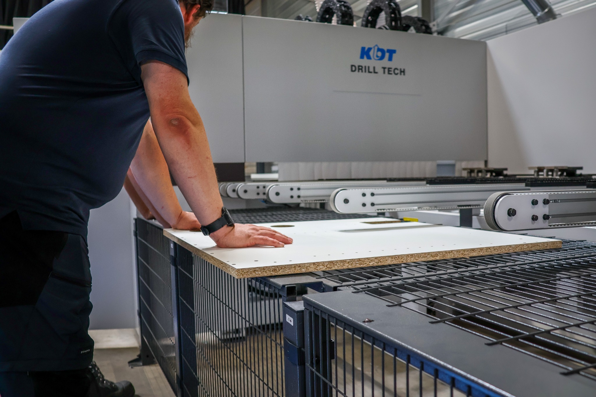 Een bewerkte meubelplaat op de rollenbaan van een KDT-boormachine.