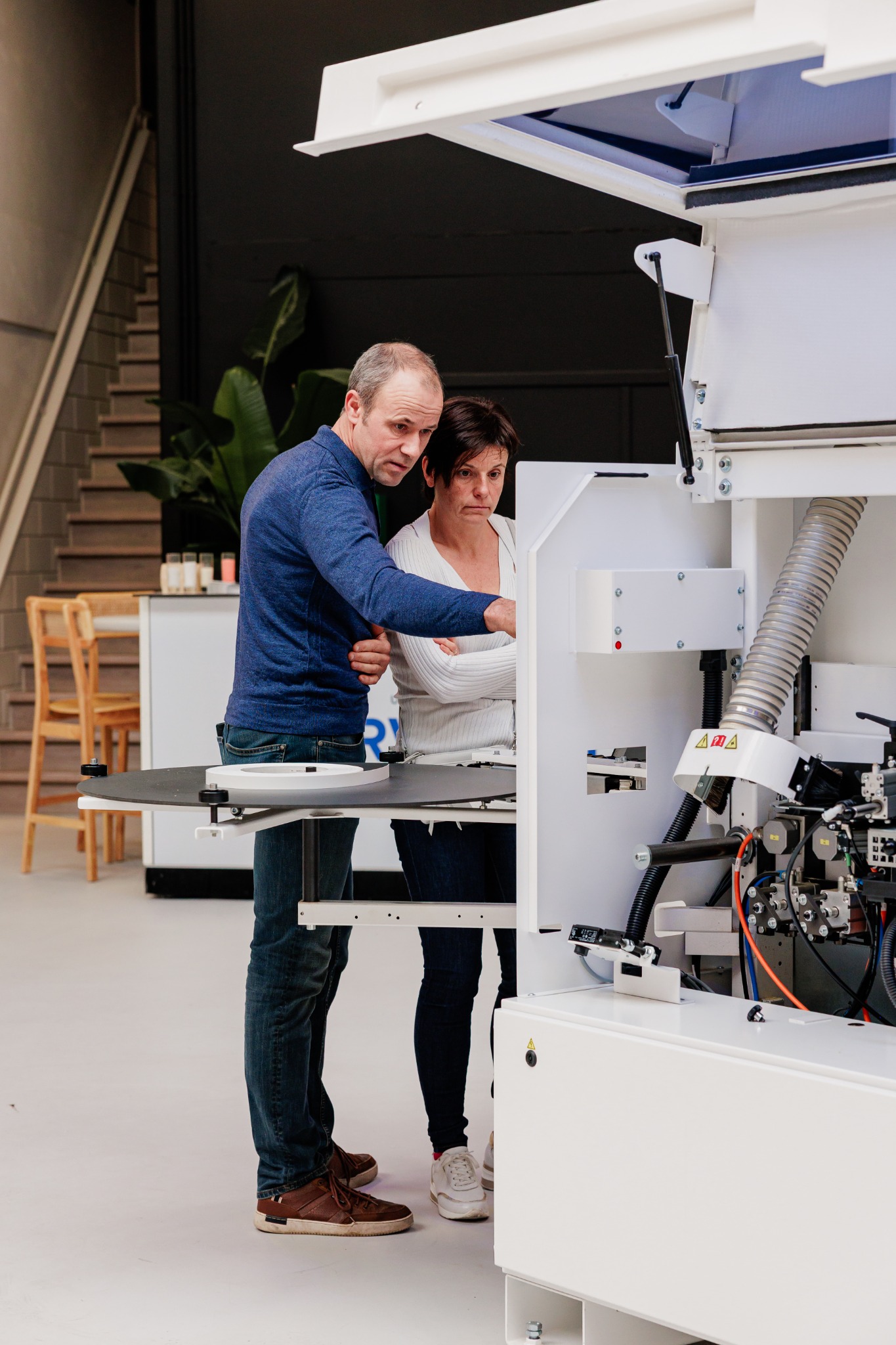 Een specialist legt een machinewerking uit aan een bezoeker.