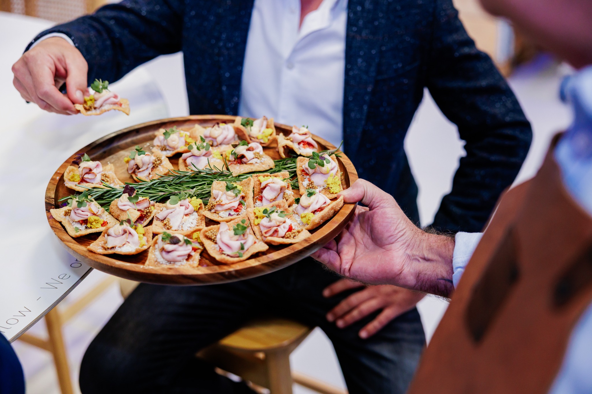 Een medewerker presenteert hapjes tijdens een eerder OPTIMAT-evenement.